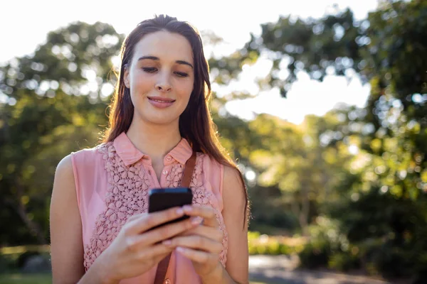 Kobieta za pomocą jej telefon w parku — Zdjęcie stockowe