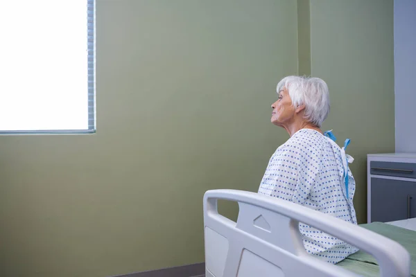 Paciente sênior sentado no hospital — Fotografia de Stock