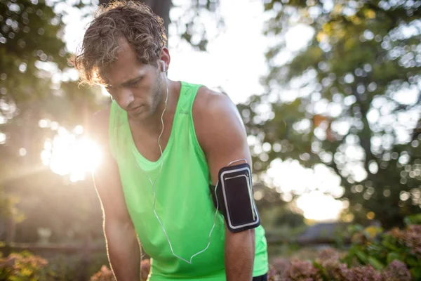 Homme fatigué prenant une profonde respiration tout en faisant du jogging — Photo