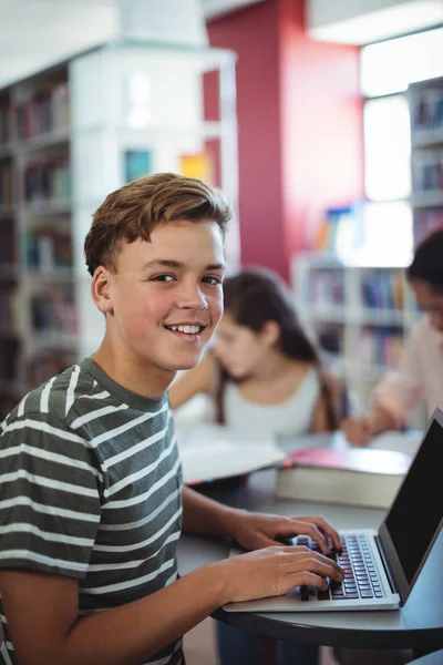 Attente student via laptop in bibliotheek — Stockfoto