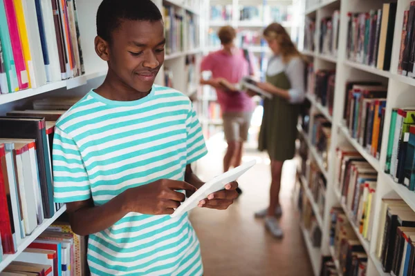 Attente schooljongen via digitale tablet in bibliotheek — Stockfoto