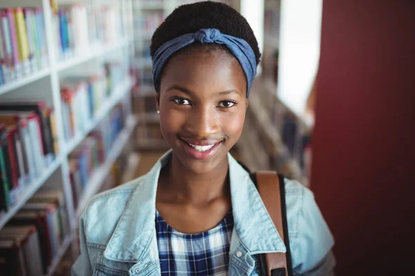 Uczennica uśmiechający się w bibliotece — Zdjęcie stockowe