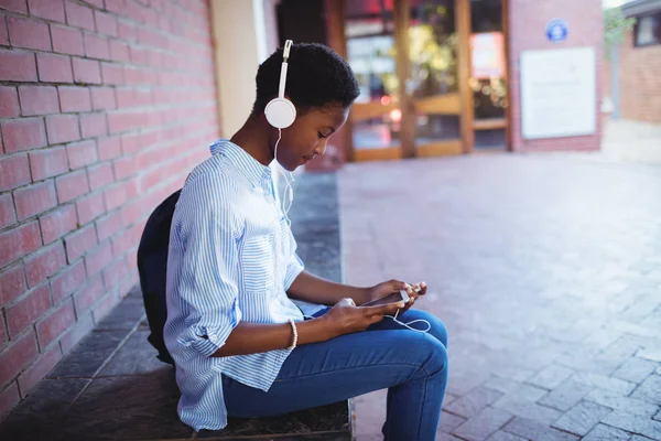 Estudante ouvindo música no celular — Fotografia de Stock
