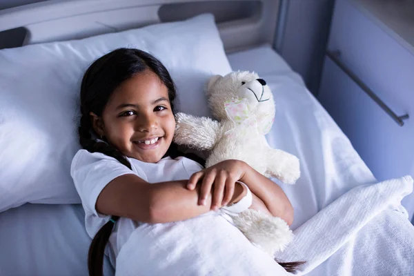 Patiënt ontspannen op bed met teddybeer — Stockfoto
