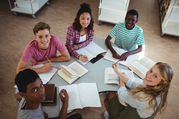 Compañeros de clase felices estudiando en la biblioteca —  Fotos de Stock