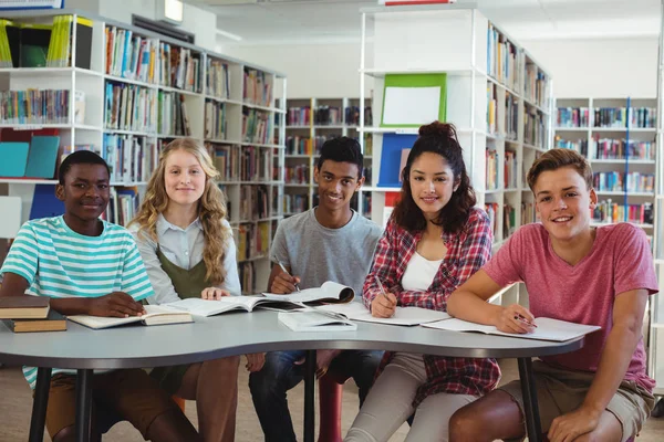 Compagni di classe felici che studiano in biblioteca — Foto Stock