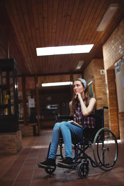 Écolière handicapée en fauteuil roulant dans le couloir — Photo