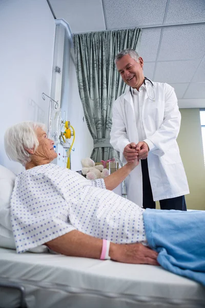 Doctor consoling senior patient in ward — Stock Photo, Image