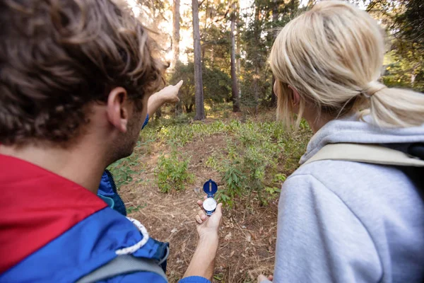 Pěší turistika pár hospodářství kompas a směřující dopředu — Stock fotografie