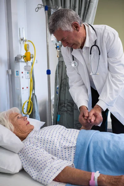 Doctor examining senior patient in ward — Stock Photo, Image