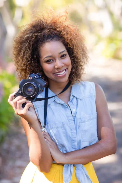 Femme debout avec appareil photo numérique — Photo