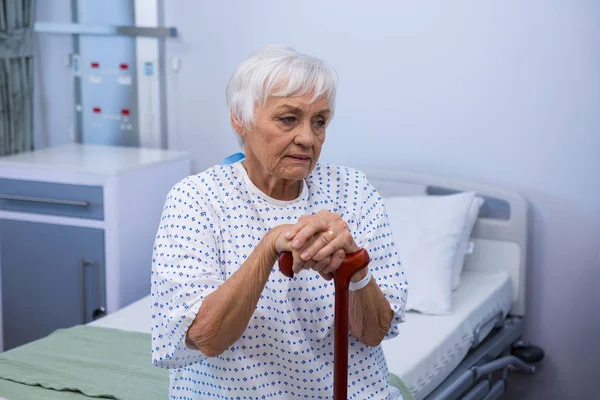 Besorgte Seniorin sitzt auf Bett — Stockfoto