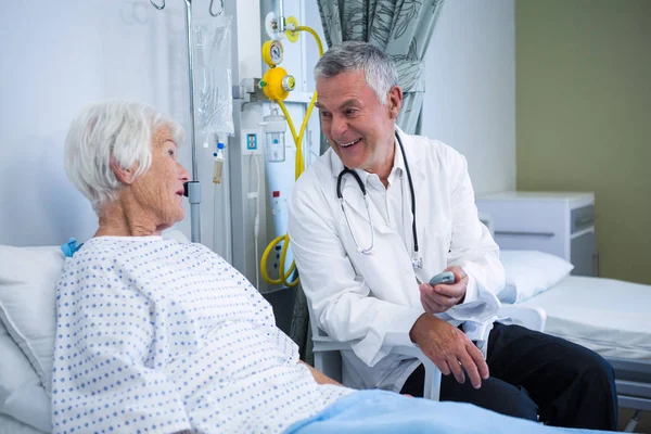 Doctor interacting with senior patient in ward — Stock Photo, Image