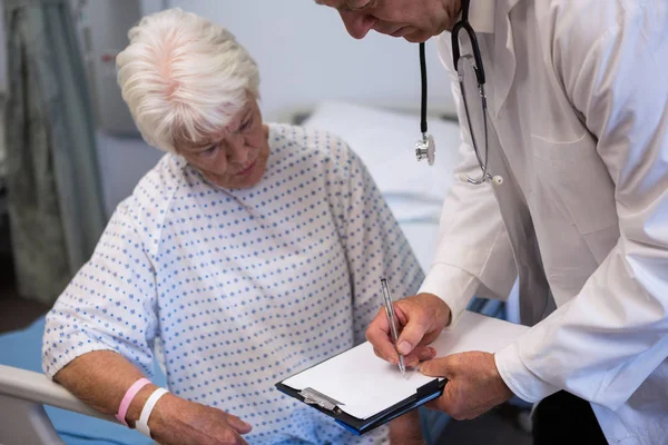Médecin discutant du rapport médical avec un patient âgé — Photo