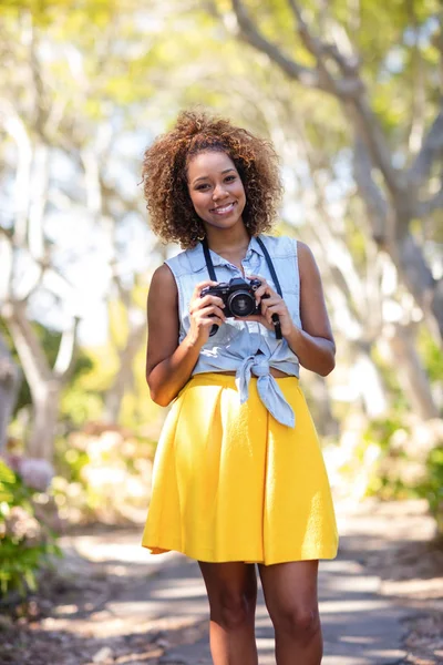 Femme debout avec appareil photo numérique — Photo