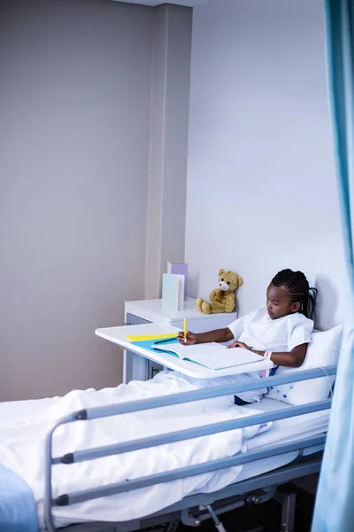 Pacjenta, pisanie na książce siedząc — Zdjęcie stockowe