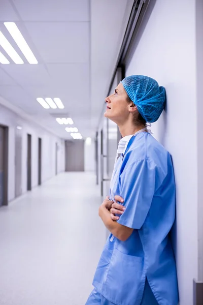 Sorgliga kirurg lutad mot väggen i korridoren — Stockfoto