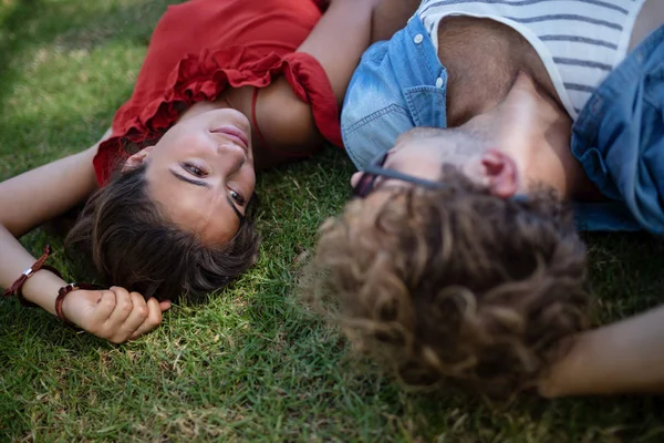 Casal deitado na grama no parque — Fotografia de Stock