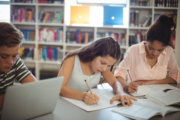 Estudantes atentos estudando na biblioteca — Fotografia de Stock