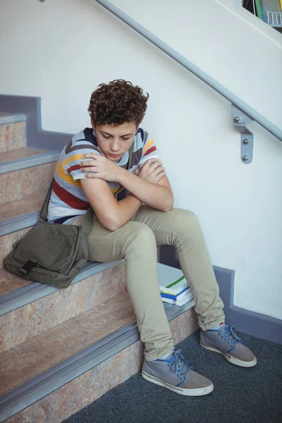 Yalnız merdiven üzerinde oturan üzgün okul çocuğu — Stok fotoğraf