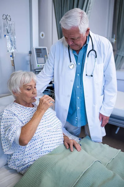 Старший пациент пьет стакан воды — стоковое фото