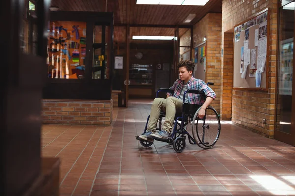 Écolier handicapé en fauteuil roulant dans le couloir — Photo