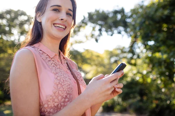 Woman using her phone in the park — Stock Photo, Image