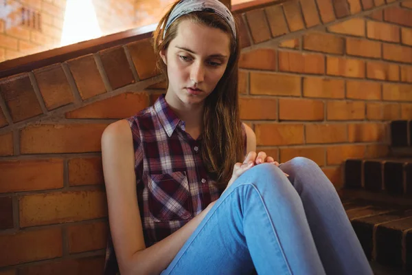 Triste colegiala sentada sola en la escalera — Foto de Stock