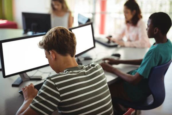 Studenten met behulp van de computer in de klas — Stockfoto