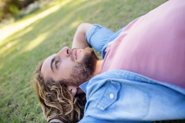 Hombre reflexivo acostado en la hierba — Foto de Stock