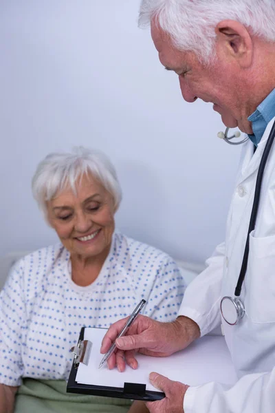 Médecin discutant du rapport médical avec un patient âgé — Photo