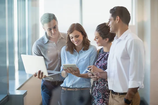 Collega's met behulp van telefoon-, Tablet PC- en laptop — Stockfoto