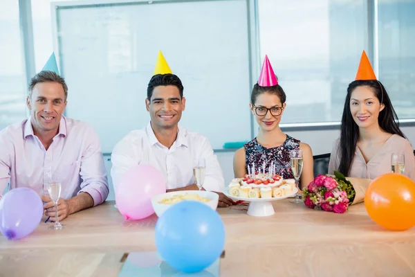 Улыбающиеся коллеги празднуют день рождения женщины — стоковое фото
