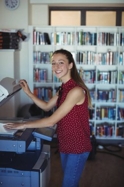 schoolgirl using Xerox photocopier in library clipart