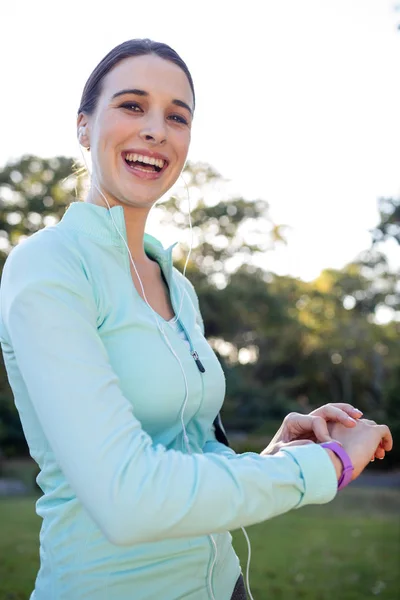 Kvinnliga joggaren kontrollera hennes fitness band — Stockfoto