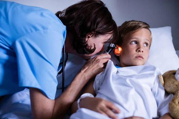 Доктор осматривает ухо пациента с помощью отоскопа — стоковое фото