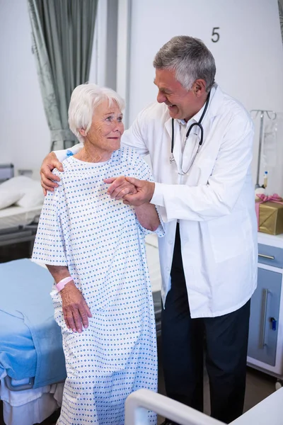 Dokter meewerkende senior patiënt in ward — Stockfoto