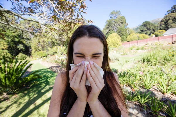 Mulher soprando nariz com papel tissue — Fotografia de Stock