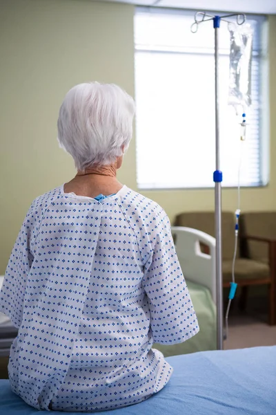 Paciente idoso pensativo sentado no hospital — Fotografia de Stock
