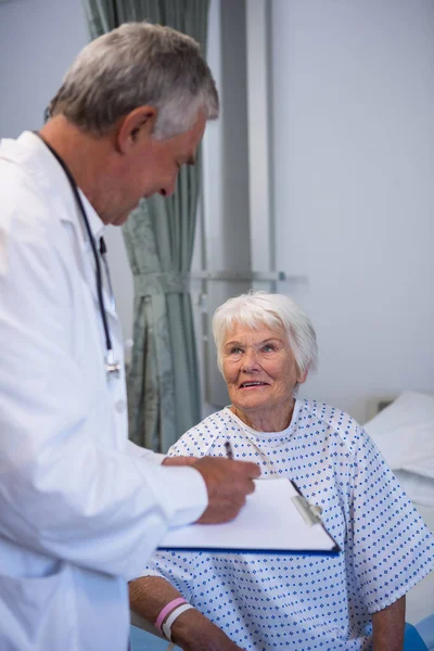 Läkare diskuterar medicinsk rapport med senior patienten — Stockfoto