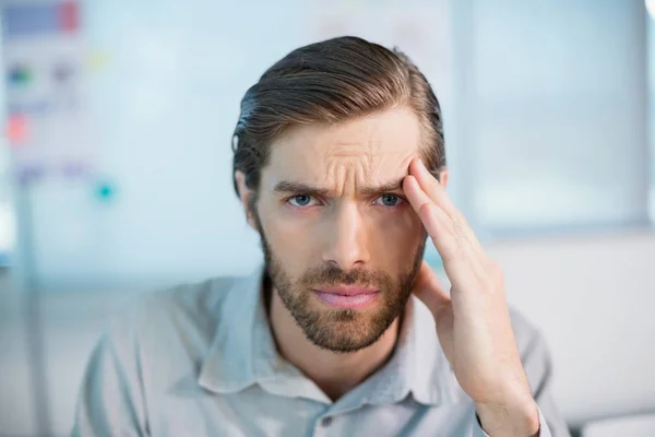 Angespannte Geschäftsführung sitzt mit der Hand auf der Stirn — Stockfoto