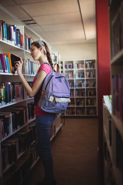 Μαθήτρια επιλέγοντας βιβλίο στη βιβλιοθήκη — Φωτογραφία Αρχείου