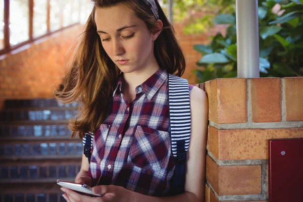 Attente schoolmeisje met behulp van de telefoon in de buurt van trap — Stockfoto