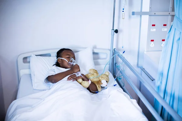 Patient sleeping with teddy bear on bed — Stock Photo, Image