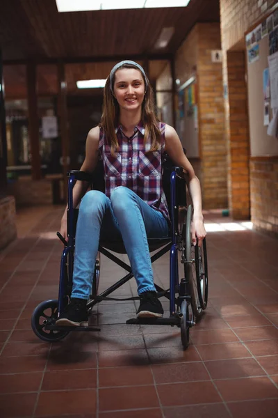 Инвалидная школьница на инвалидной коляске в коридоре — стоковое фото