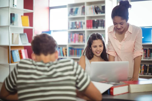 Studentów korzysta z laptopa w bibliotece — Zdjęcie stockowe