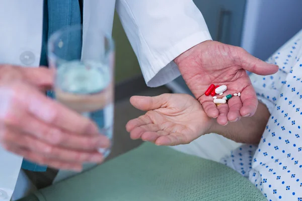 Doctor giving medicine pill to patient — Stock Photo, Image