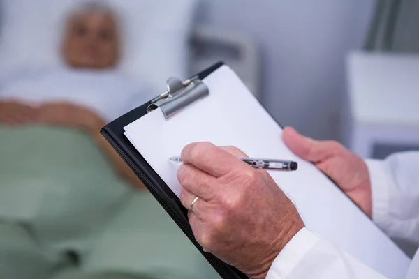 Doctor writing on clipboard — Stock Photo, Image