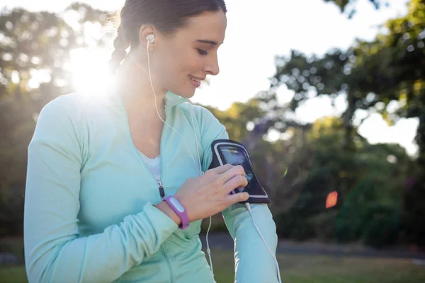 Kvinnliga joggaren Lyssna på musik på telefonen — Stockfoto