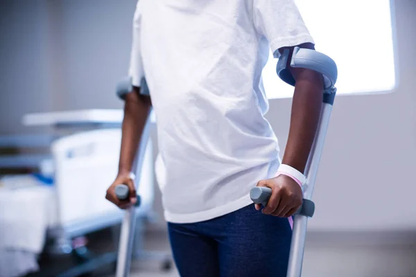 Menina andando com muletas na enfermaria — Fotografia de Stock